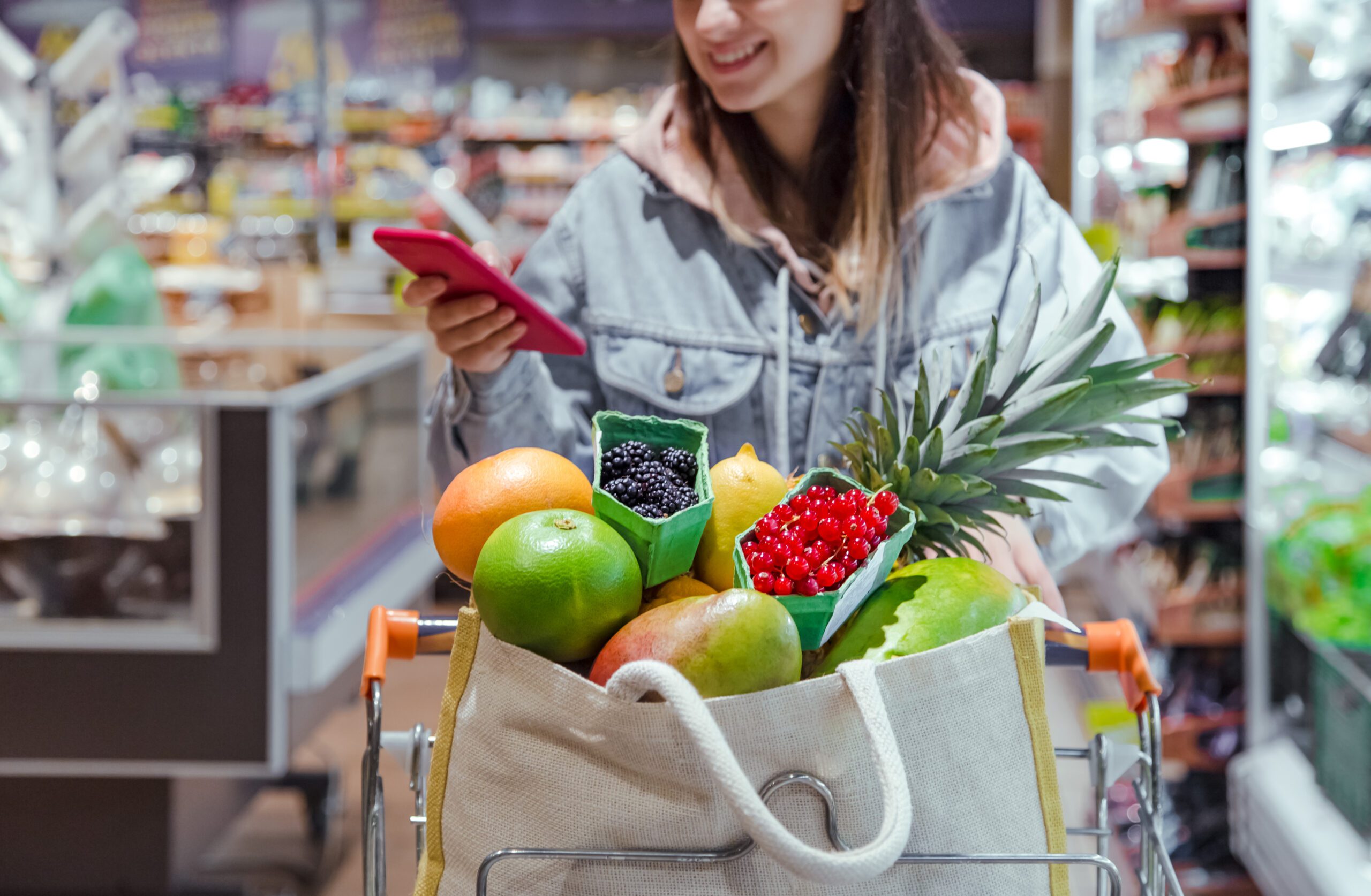 young-woman-buys-groceries-supermarket-with-phone-her-hands